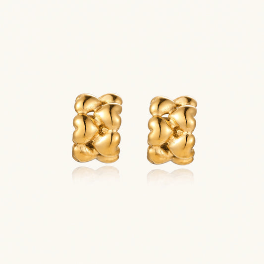 Close-up of gold-plated twisted rope huggie hoop earrings with brushed finish on white background.
