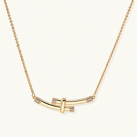 Gold-plated curved bar necklace with diamond accents on delicate chain against cream background