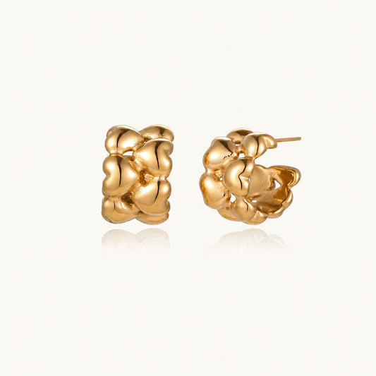 Close-up of gold-plated twisted rope huggie hoop earrings with brushed finish on white background.