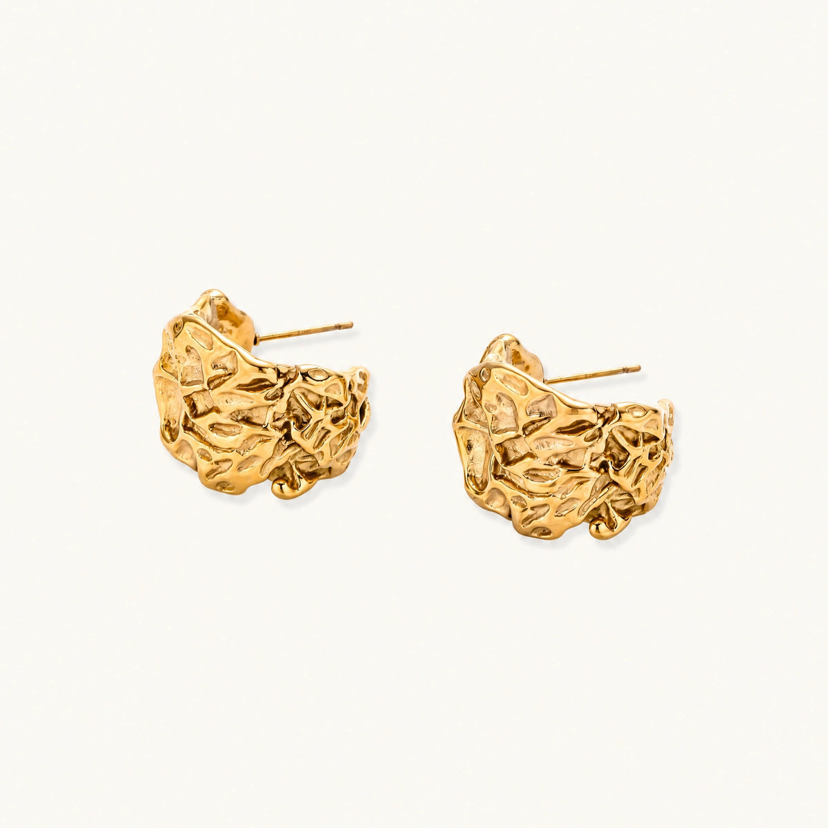 Chunky gold-plated hoop earrings with organic crumpled texture on cream background, 21.5mm sculptural design
