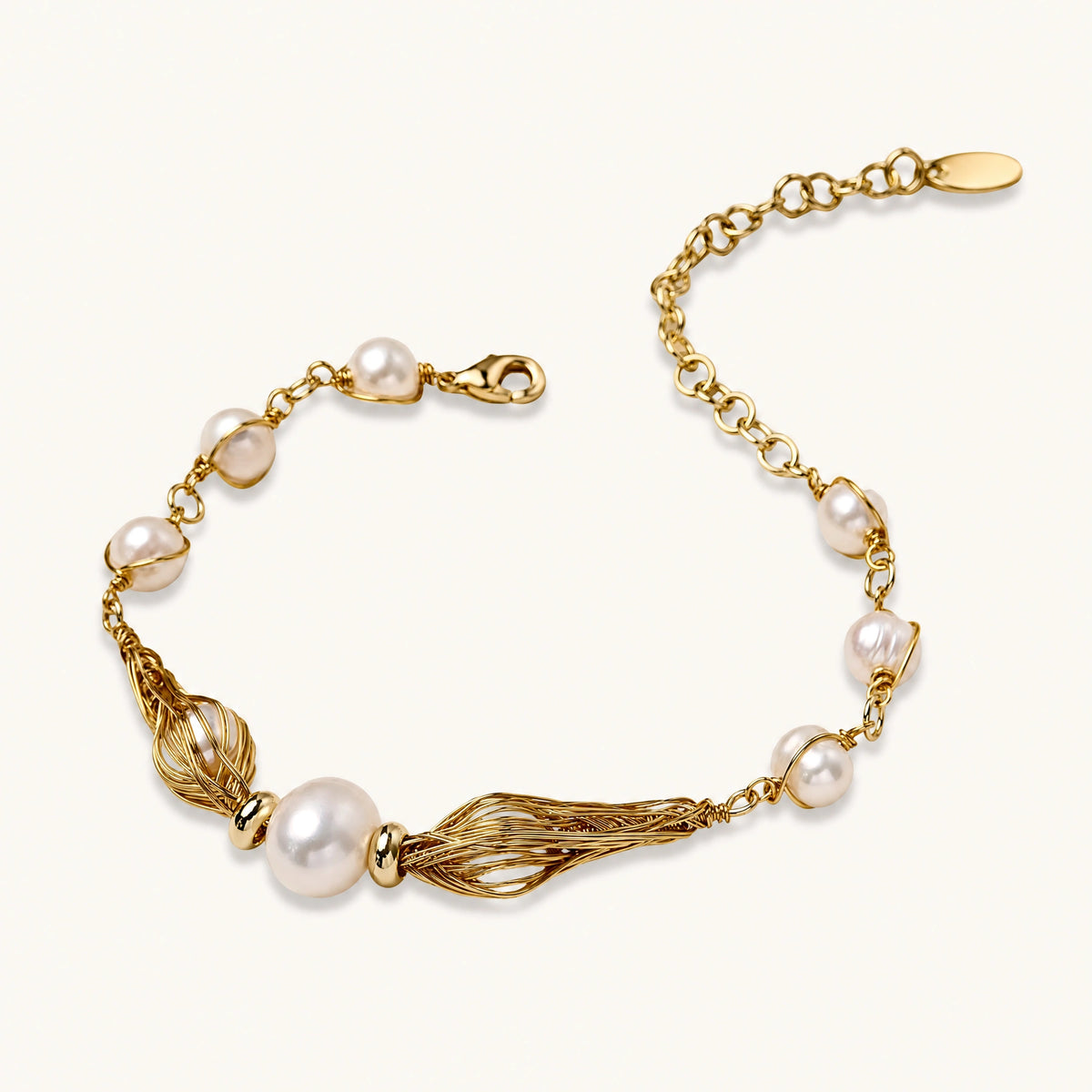 Adjustable gold bracelet with freshwater pearls and textured filigree beads on white background, showing clasp detail.