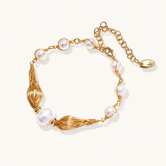 Adjustable gold bracelet with freshwater pearls and textured filigree beads on white background, showing clasp detail.